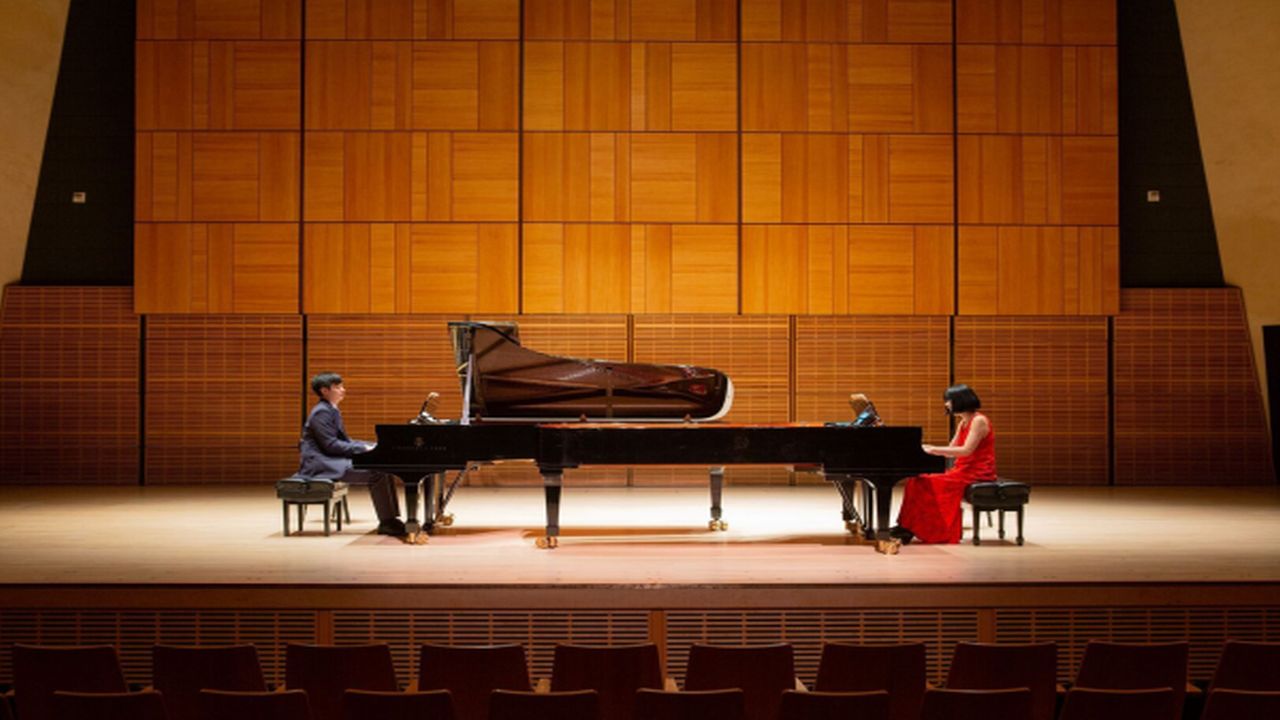 Two pianists perform on stage during a concert benefiting LSS.